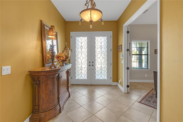 foyer entrance featuring light tile patterned floors, baseboards, visible vents, and french doors