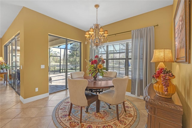 dining area featuring light tile patterned floors, baseboards, and a notable chandelier