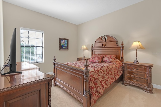 bedroom with light colored carpet and baseboards