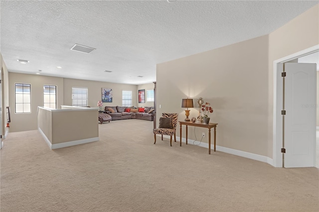 living room with light carpet, a textured ceiling, and baseboards