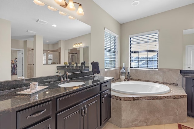 full bathroom featuring visible vents, walk in shower, vanity, and a bath