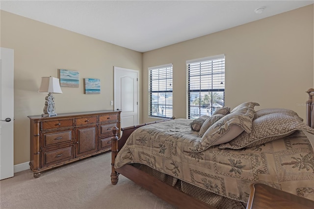 bedroom with light carpet and baseboards