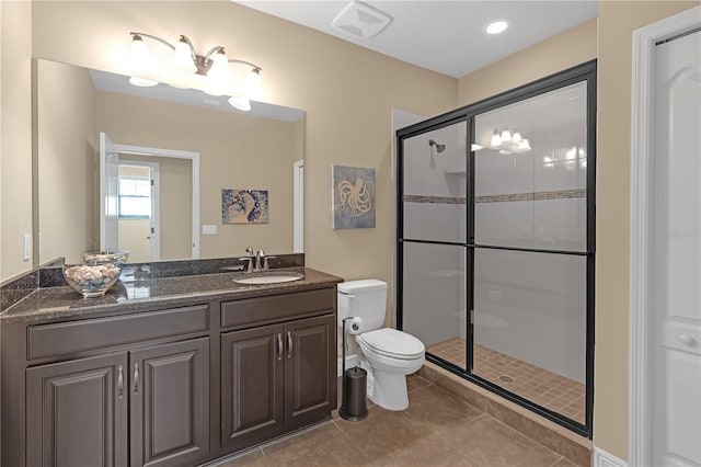 bathroom with a stall shower, vanity, toilet, and tile patterned floors