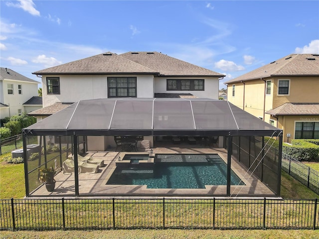 view of pool featuring a patio area, a fenced backyard, a pool with connected hot tub, and a lanai