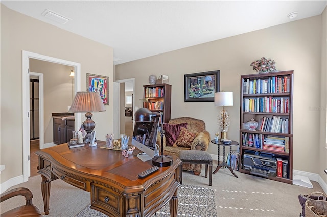 carpeted office space featuring visible vents and baseboards