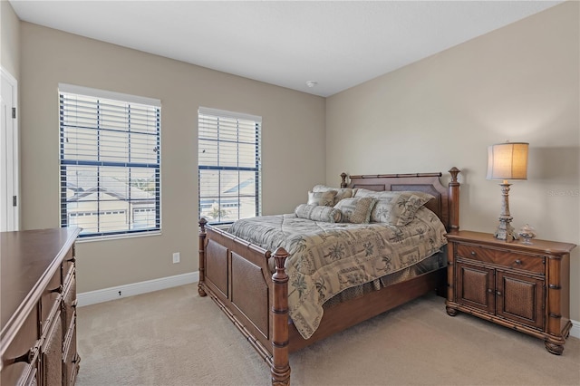 bedroom featuring light carpet and baseboards