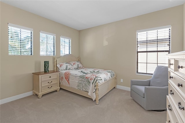 bedroom featuring light carpet and baseboards