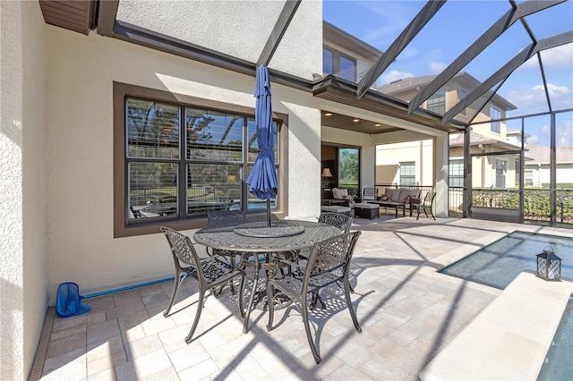 view of patio / terrace with glass enclosure and an outdoor living space with a fire pit