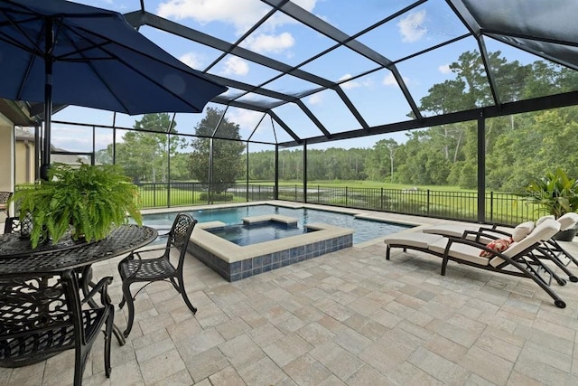 view of pool featuring glass enclosure, a patio area, a pool with connected hot tub, and fence