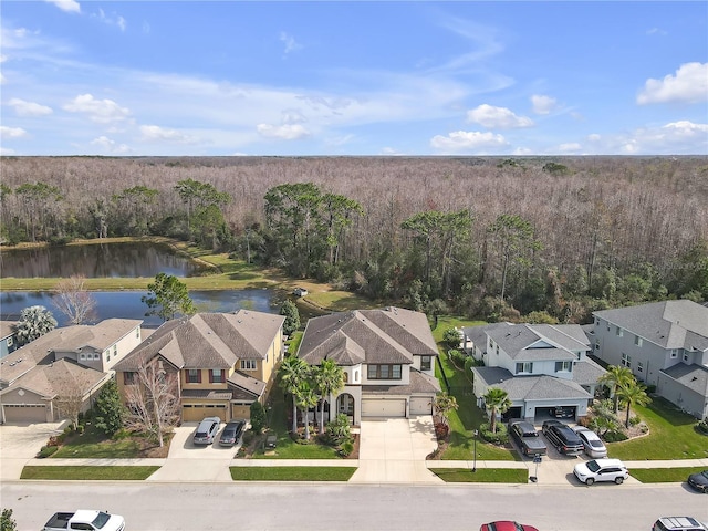 bird's eye view with a water view, a wooded view, and a residential view