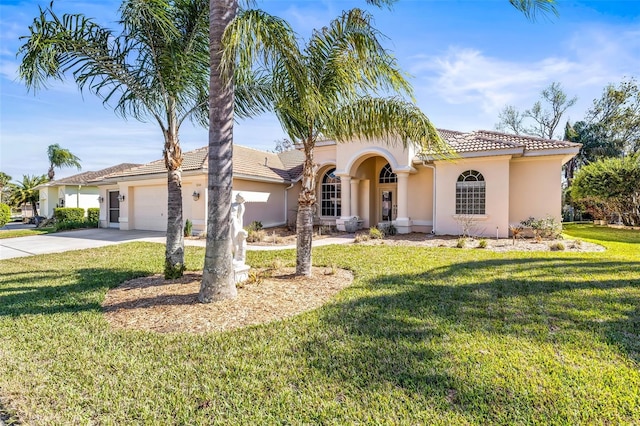 mediterranean / spanish house featuring a garage, a tile roof, concrete driveway, stucco siding, and a front lawn