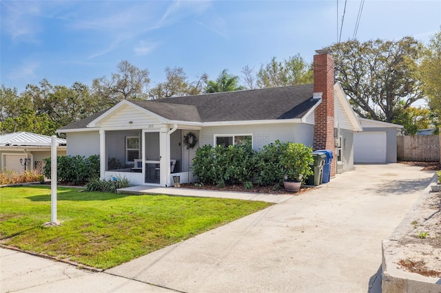 view of front of house featuring brick siding, a chimney, a front lawn, and a sunroom