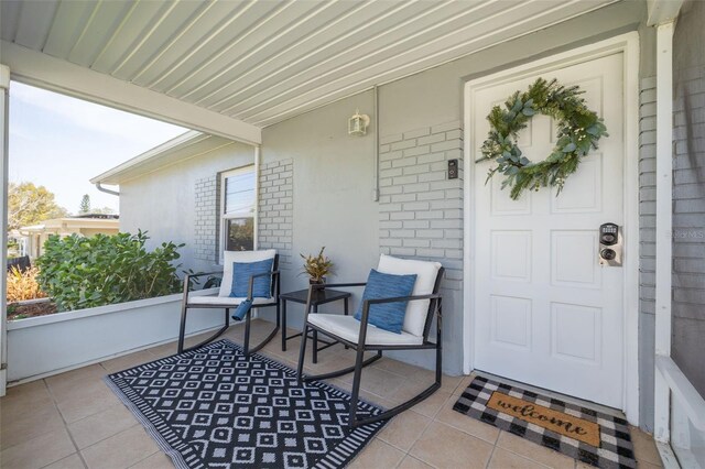 entrance to property with brick siding and covered porch