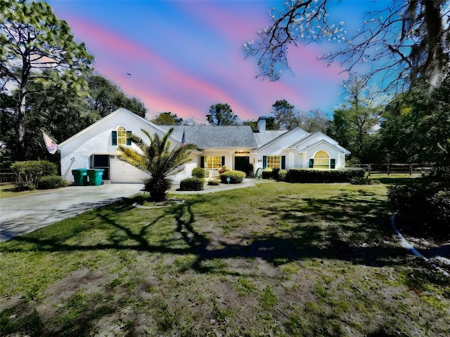 4797 N Lena Dr, Beverly Hills, FL 34465 - view of front facade with a chimney, fence, a front lawn, stucco siding, and driveway