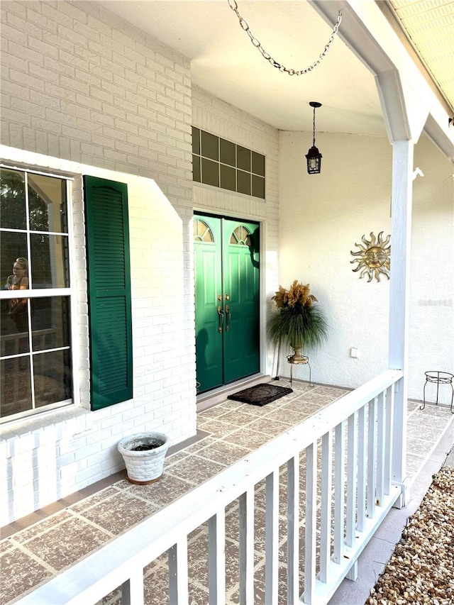 4797 N Lena Dr, Beverly Hills, FL 34465 - view of exterior entry with brick siding, french doors, and covered porch
