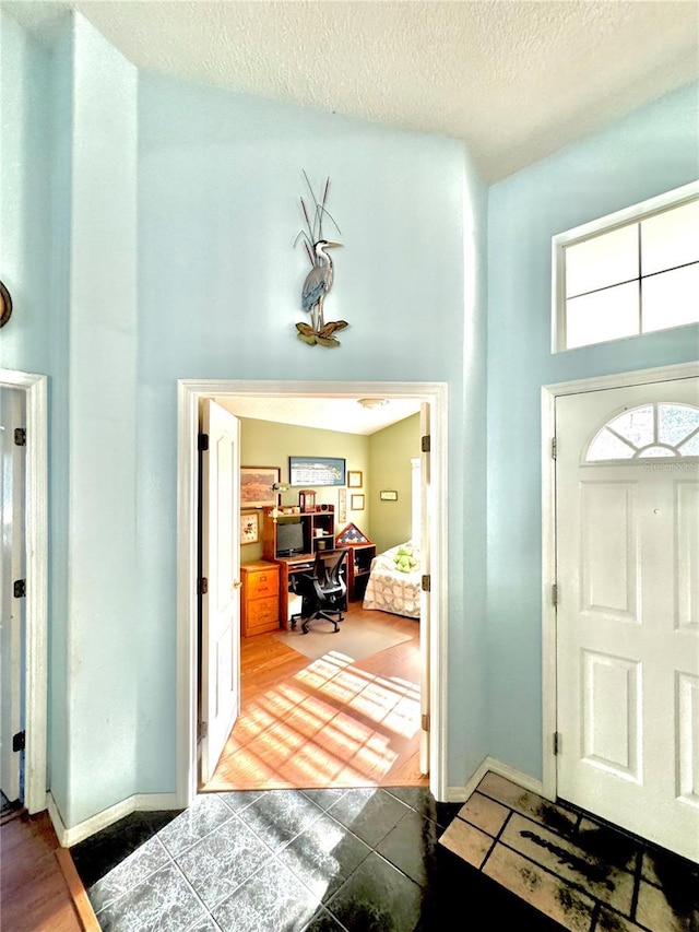 4797 N Lena Dr, Beverly Hills, FL 34465 - entrance foyer with baseboards, a towering ceiling, and a textured ceiling