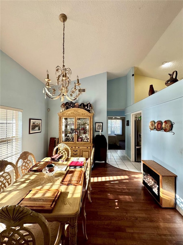 4797 N Lena Dr, Beverly Hills, FL 34465 - dining space featuring high vaulted ceiling, wood-type flooring, a chandelier, and a textured ceiling
