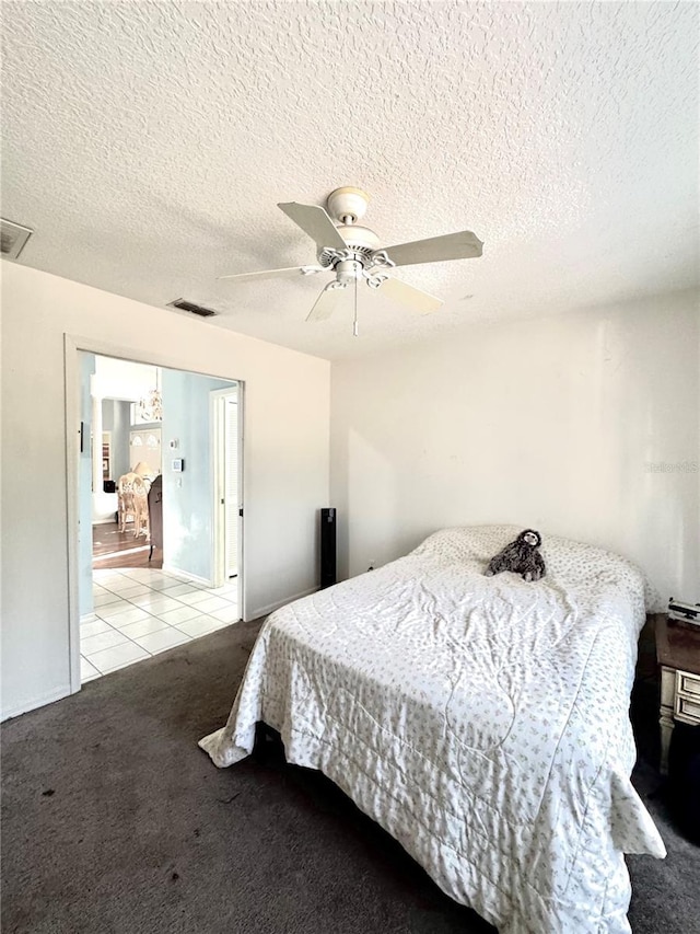 4797 N Lena Dr, Beverly Hills, FL 34465 - tiled bedroom with a textured ceiling, carpet, visible vents, and a ceiling fan