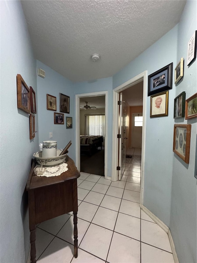 4797 N Lena Dr, Beverly Hills, FL 34465 - hallway with baseboards, light tile patterned flooring, and a textured ceiling