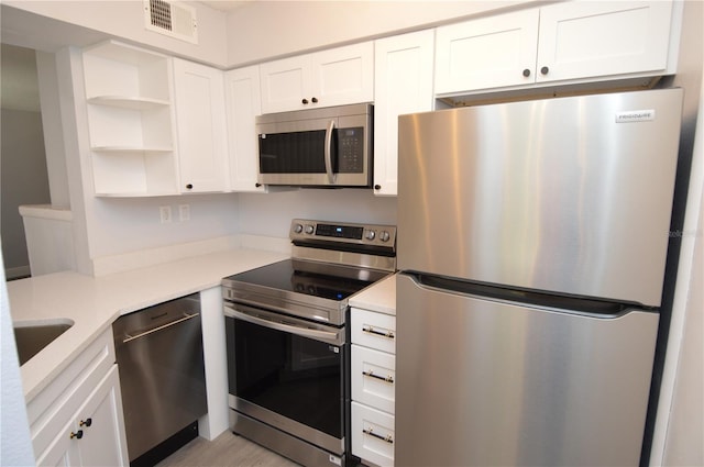 kitchen with appliances with stainless steel finishes, sink, and white cabinetry