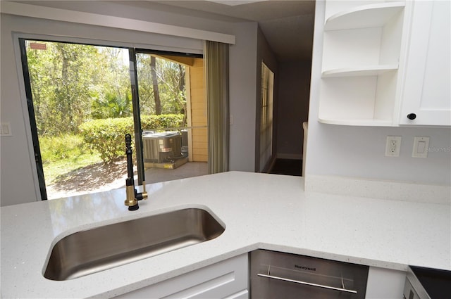 kitchen with sink, white cabinetry, light stone counters, and dishwasher