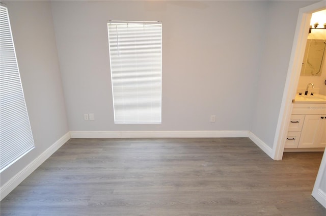 spare room with sink and light hardwood / wood-style floors