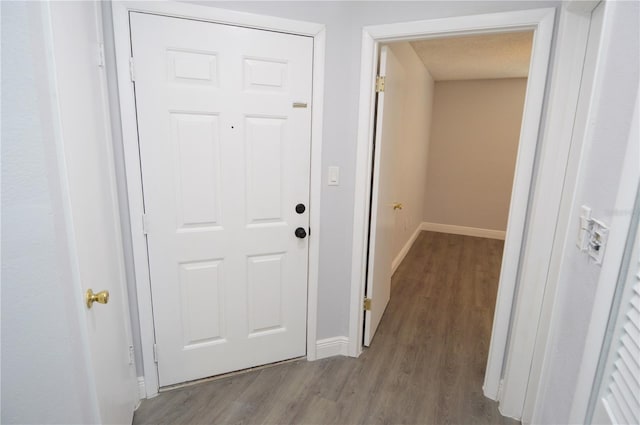 hallway with light wood-type flooring and a textured ceiling