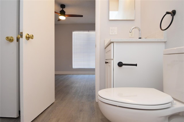 bathroom featuring toilet, wood-type flooring, vanity, and ceiling fan