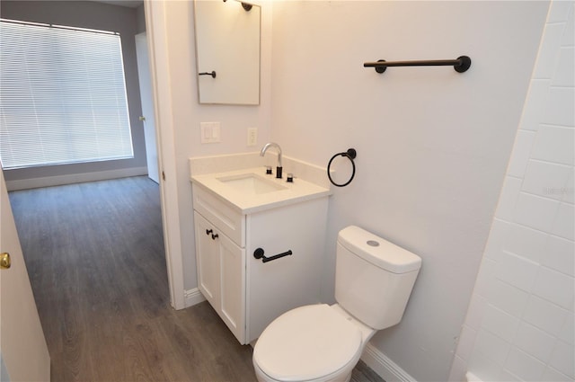 bathroom with hardwood / wood-style floors, vanity, and toilet