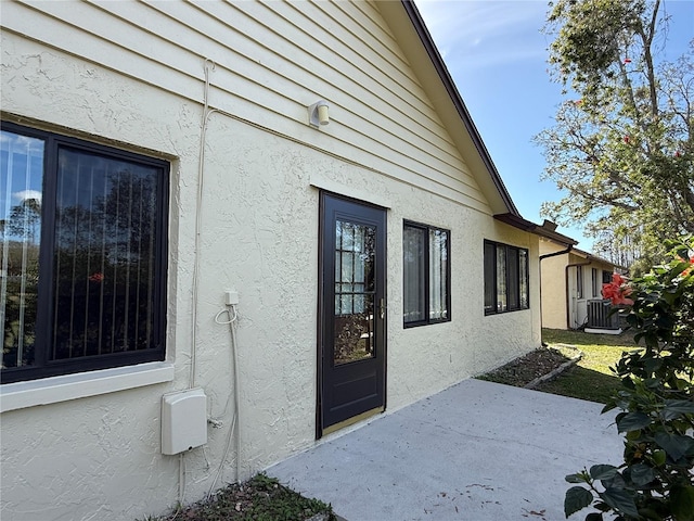 exterior space with central AC unit and a patio