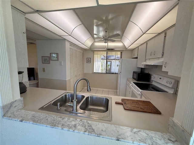 kitchen featuring kitchen peninsula, sink, white appliances, ceiling fan, and a raised ceiling