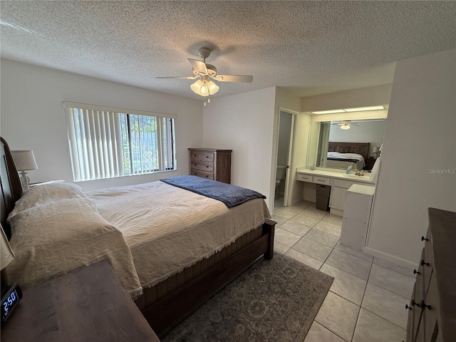 bedroom featuring a textured ceiling, ceiling fan, ensuite bath, and light tile patterned floors