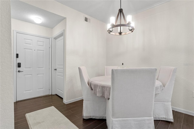 dining area with visible vents, wood finish floors, baseboards, and an inviting chandelier