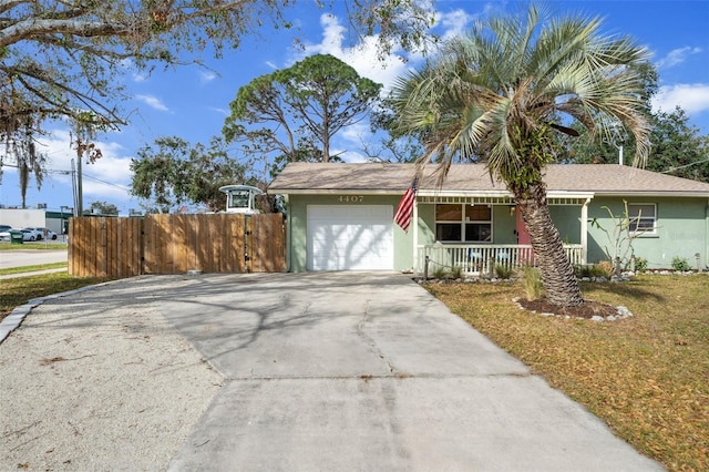 ranch-style home featuring concrete driveway, an attached garage, covered porch, fence, and stucco siding