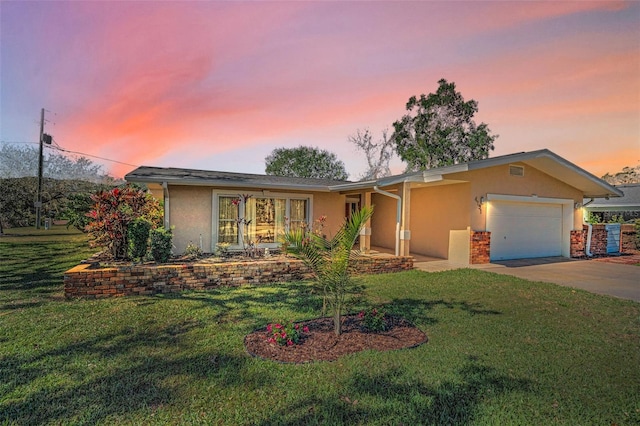 ranch-style house featuring a garage and a lawn