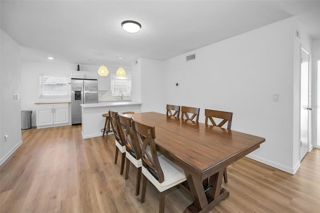 dining room featuring sink and light hardwood / wood-style floors