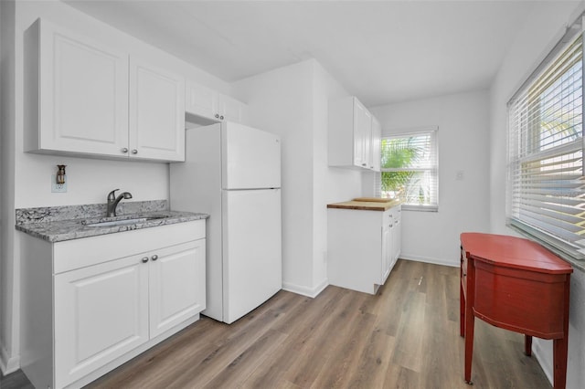 kitchen featuring sink, white cabinets, white fridge, and light wood-type flooring