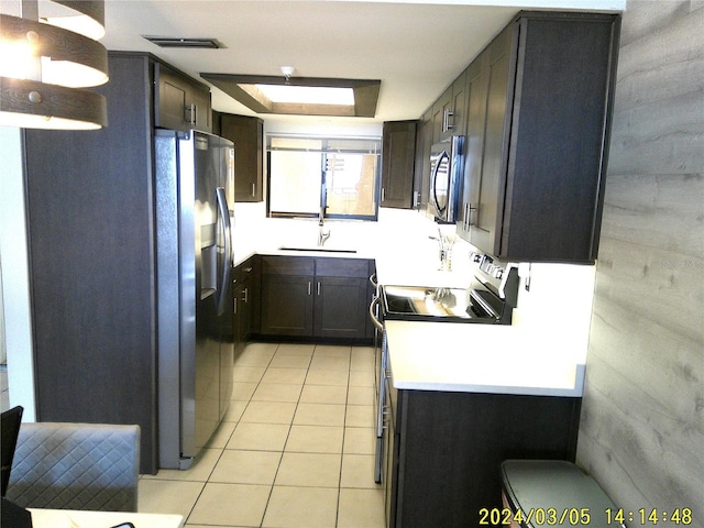 kitchen with light tile patterned floors, appliances with stainless steel finishes, light countertops, and a sink