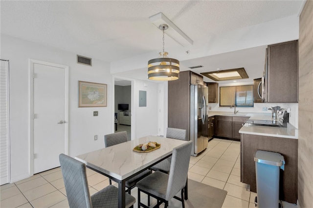 dining space with visible vents, a textured ceiling, and light tile patterned flooring