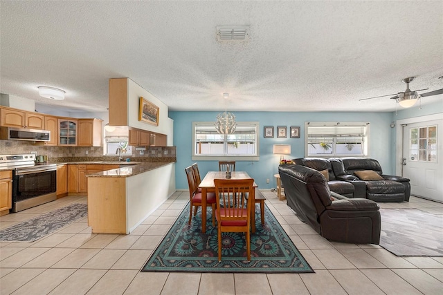 dining area featuring light tile patterned floors, a textured ceiling, ceiling fan with notable chandelier, and visible vents