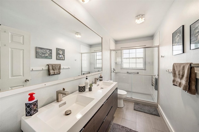 bathroom featuring a sink, a shower stall, and toilet