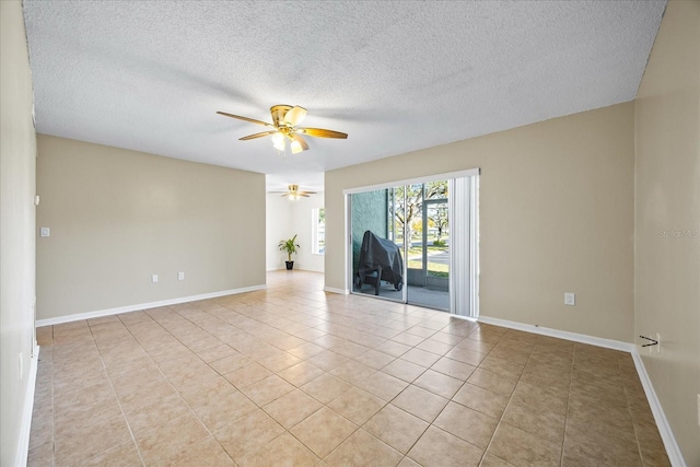 tiled empty room featuring ceiling fan and a textured ceiling