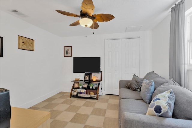 living room with visible vents, light floors, baseboards, and ceiling fan