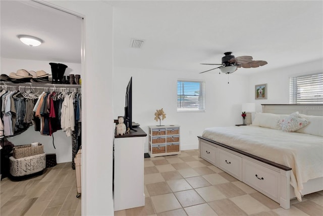 bedroom featuring a closet, visible vents, multiple windows, and a ceiling fan