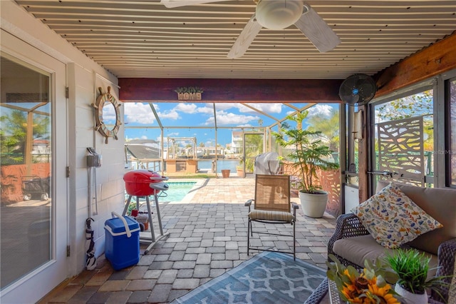 view of patio featuring a lanai, a ceiling fan, an outdoor pool, and a water view