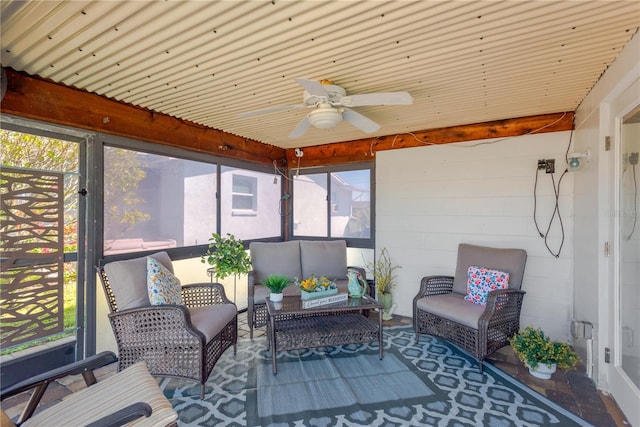 sunroom / solarium featuring a ceiling fan