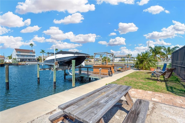 view of dock with a yard, a water view, and boat lift