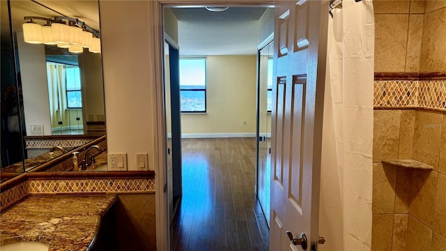 hall featuring wood finished floors and baseboards