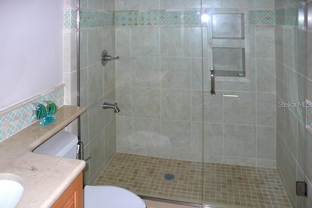 full bathroom with toilet, a shower stall, and vanity