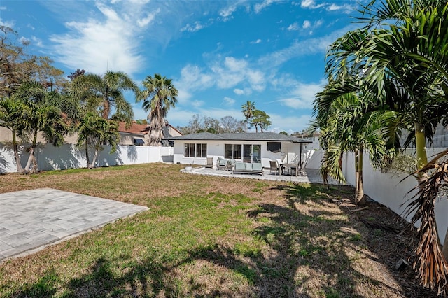 rear view of house featuring a yard and a patio